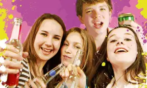 Jugendschutzgesetz alkohol private feier: Vier lachende Jugendliche halten Flaschen und eine Dose.