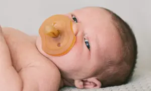 Ein Neugeborenes mit Schnuller. Die Frage "ab wann Schnuller Baby?" beschäftigt viele Eltern.