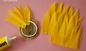 Sonnenblume basteln Krippe: Gelbe Blütenblätter aus Krepppapier werden auf einen Teebeutel geklebt.