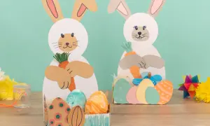 Zwei Bastelhasen mit Karotten und Ostereiern, eine schöne Idee für Ostern im Kindergarten.