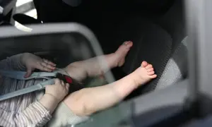 Babyfüße im Kindersitz. Ein trauriges Bild, das an das "forgotten baby syndrome" erinnert, wenn Kinder versehentlich im Auto zurückgelassen werden.