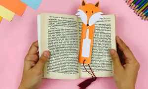 Ein Fuchs-Lesezeichen, gebastelt nach Vorlagen zum Ausdrucken, steckt in einem Buch.