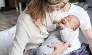 Eltern trösten ihr weinendes Baby. Die späte Stunde ist die "Hexenstunde" für das kleine Kind.