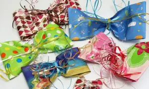 Bunte Schleifen aus Krepppapier basteln: Eine Sammlung von selbstgemachten Geschenkschleifen in verschiedenen Mustern und Farben, bereit zum Verzieren.