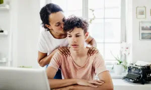 Mutter küsst Sohn auf die Stirn, legt Hände auf seine Schultern. Sie liebt ein narzisst seine Kinder, doch hier wirkt es wie echte Zuneigung.