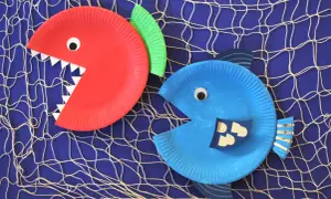 Zwei lustige Fische aus Papptellern, die zum Basteln einladen. Ein roter mit spitzen Zähnen und ein blauer mit witzigen Schuppen.