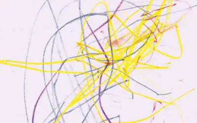 Bunte Kritzeleien in Gelb, Blau und Lila auf weißem Papier. Ein frühes Beispiel, ab wann malen Kinder ihre ersten Kunstwerke.