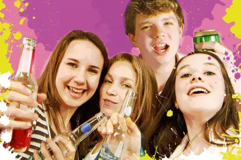Jugendschutzgesetz alkohol private feier: Vier lachende Jugendliche halten Flaschen und eine Dose.