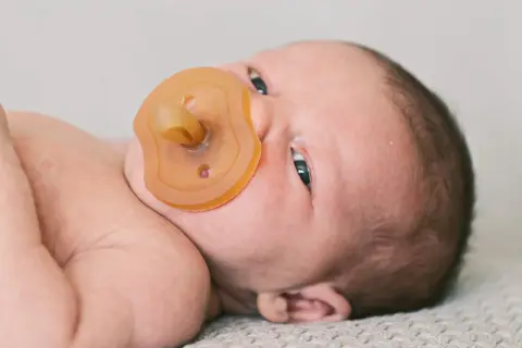Ein Neugeborenes mit Schnuller. Die Frage "ab wann Schnuller Baby?" beschäftigt viele Eltern.