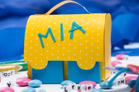 Ein gelber, gepunkteter Schulranzen zum Selberbasteln mit dem Namen "Mia" und blauen Buchstaben.