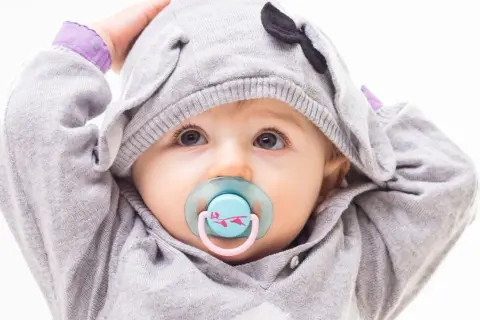 Baby mit Schnuller im süßen Elefanten-Hoodie. Bald ist er bereit zum schnuller auskochen.