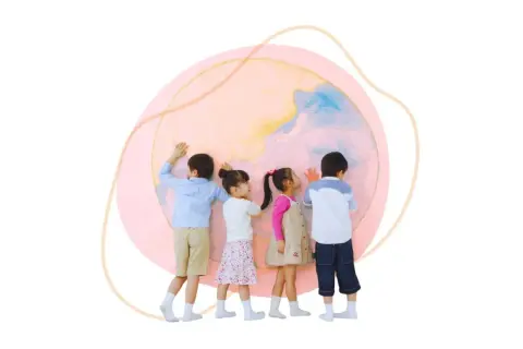 Vier Kinder betrachten eine bunte Weltkugel. Sie lernen spielerisch interkulturelle Erziehung im Kindergarten kennen und entdecken die Vielfalt.