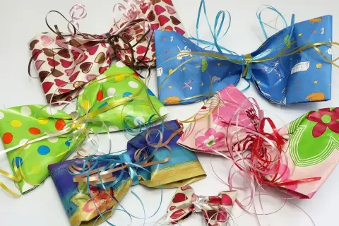 Bunte Schleifen aus Krepppapier basteln: Eine Sammlung von selbstgemachten Geschenkschleifen in verschiedenen Mustern und Farben, bereit zum Verzieren.