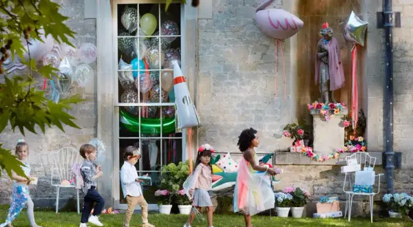 Kinder mit Geschenken und Ballons, tolle kita geburtstag ideen für eine magische Feier im Freien.