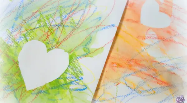 Bunte Kritzeleien, wie Kinder sie malen, mit weißen Herzen darauf. Ein Herz auf grünem, das andere auf orangem Hintergrund.