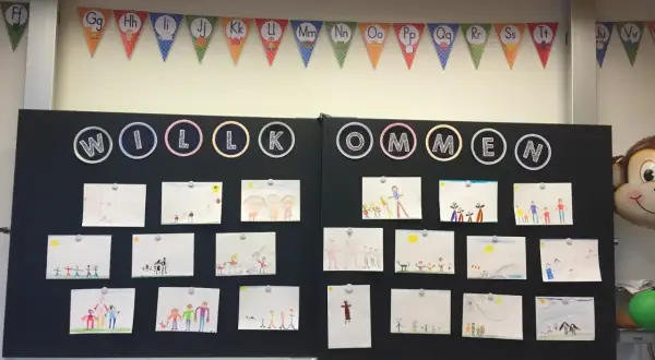 Willkommen! Kinderzeichnungen schmücken die Tafel, ein lustiger Einstieg zum Elternabend. Affenball und ABC-Girlande sorgen für gute Laune.