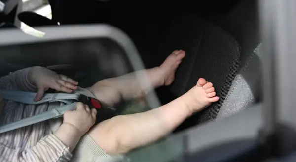 Babyfüße im Kindersitz. Ein trauriges Bild, das an das "forgotten baby syndrome" erinnert, wenn Kinder versehentlich im Auto zurückgelassen werden.