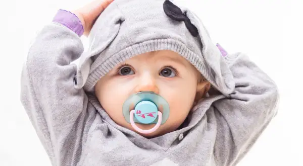 Baby mit Schnuller im süßen Elefanten-Hoodie. Bald ist er bereit zum schnuller auskochen.