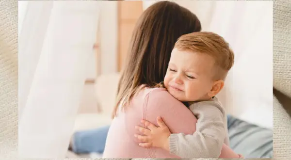 Ein weinendes Baby klammert sich an seine Mutter. Es ist ein echter Klettverschluss-Baby, das Trost sucht.