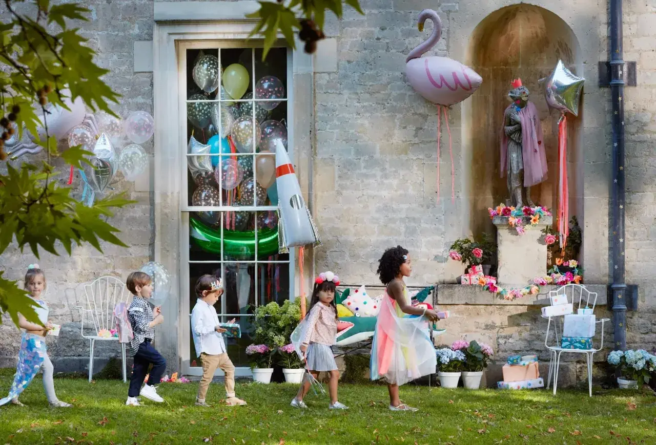 Kinder mit Geschenken und Ballons, tolle kita geburtstag ideen für eine magische Feier im Freien.