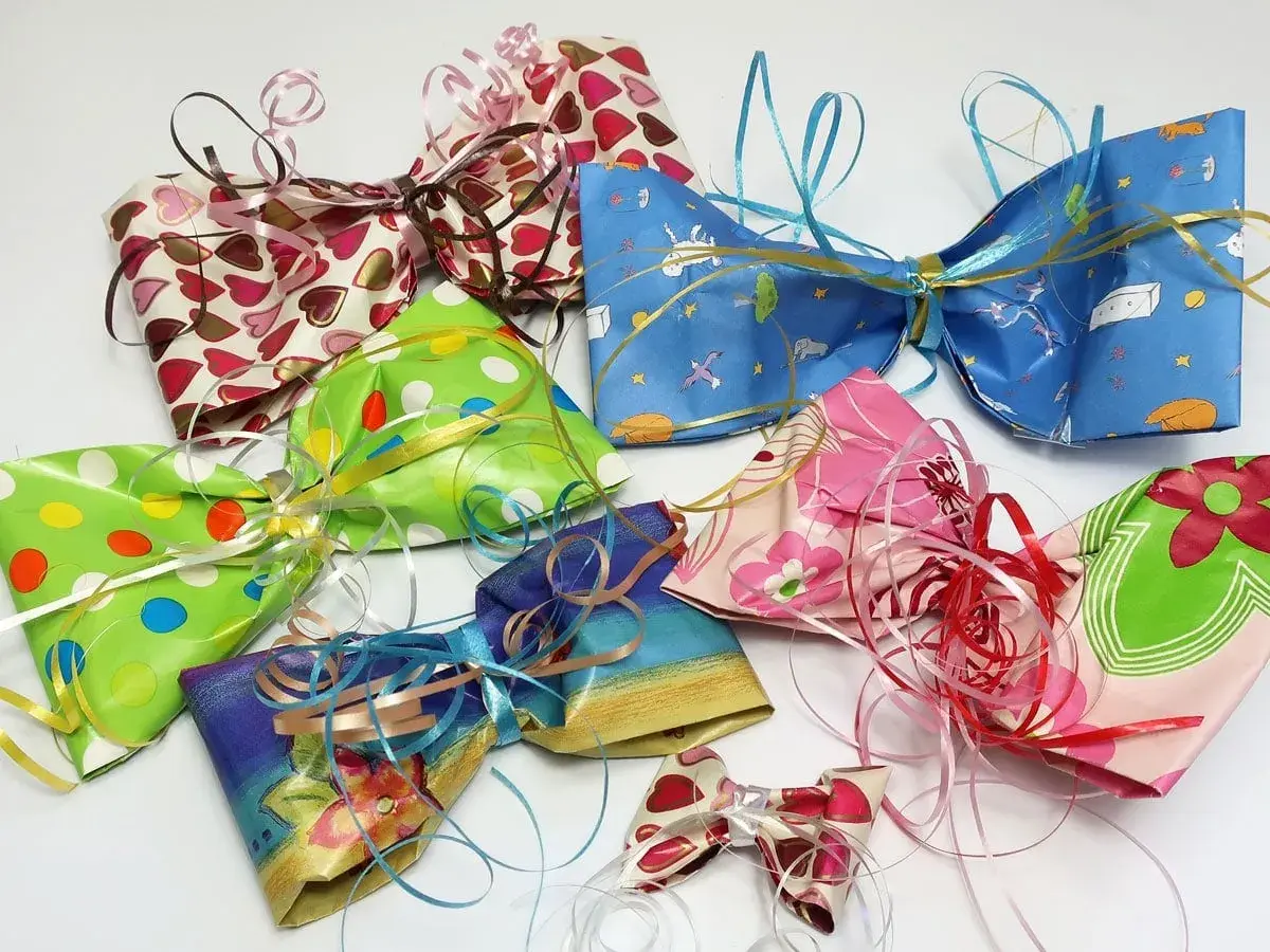 Bunte Schleifen aus Krepppapier basteln: Eine Sammlung von selbstgemachten Geschenkschleifen in verschiedenen Mustern und Farben, bereit zum Verzieren.