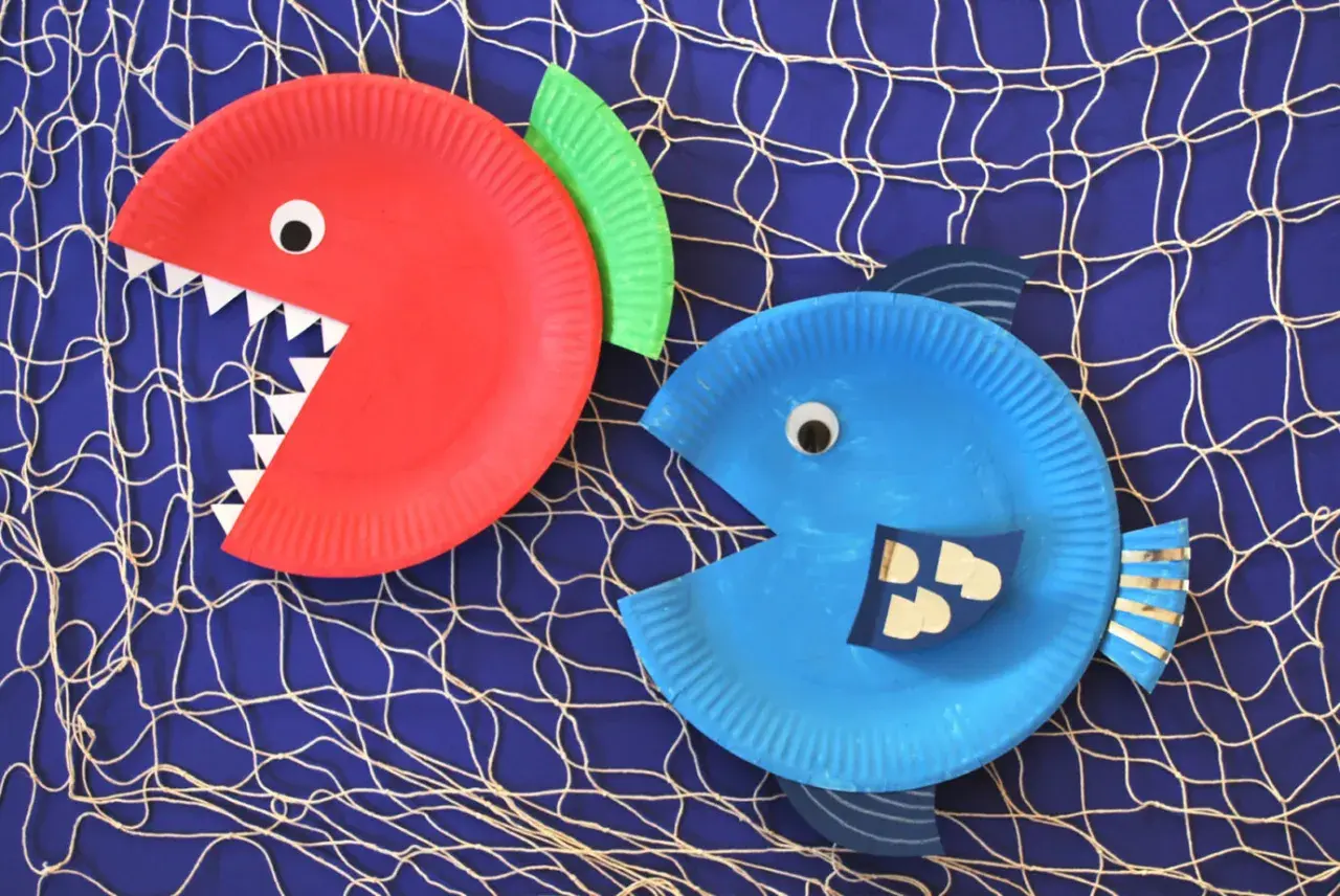 Zwei lustige Fische aus Papptellern, die zum Basteln einladen. Ein roter mit spitzen Zähnen und ein blauer mit witzigen Schuppen.