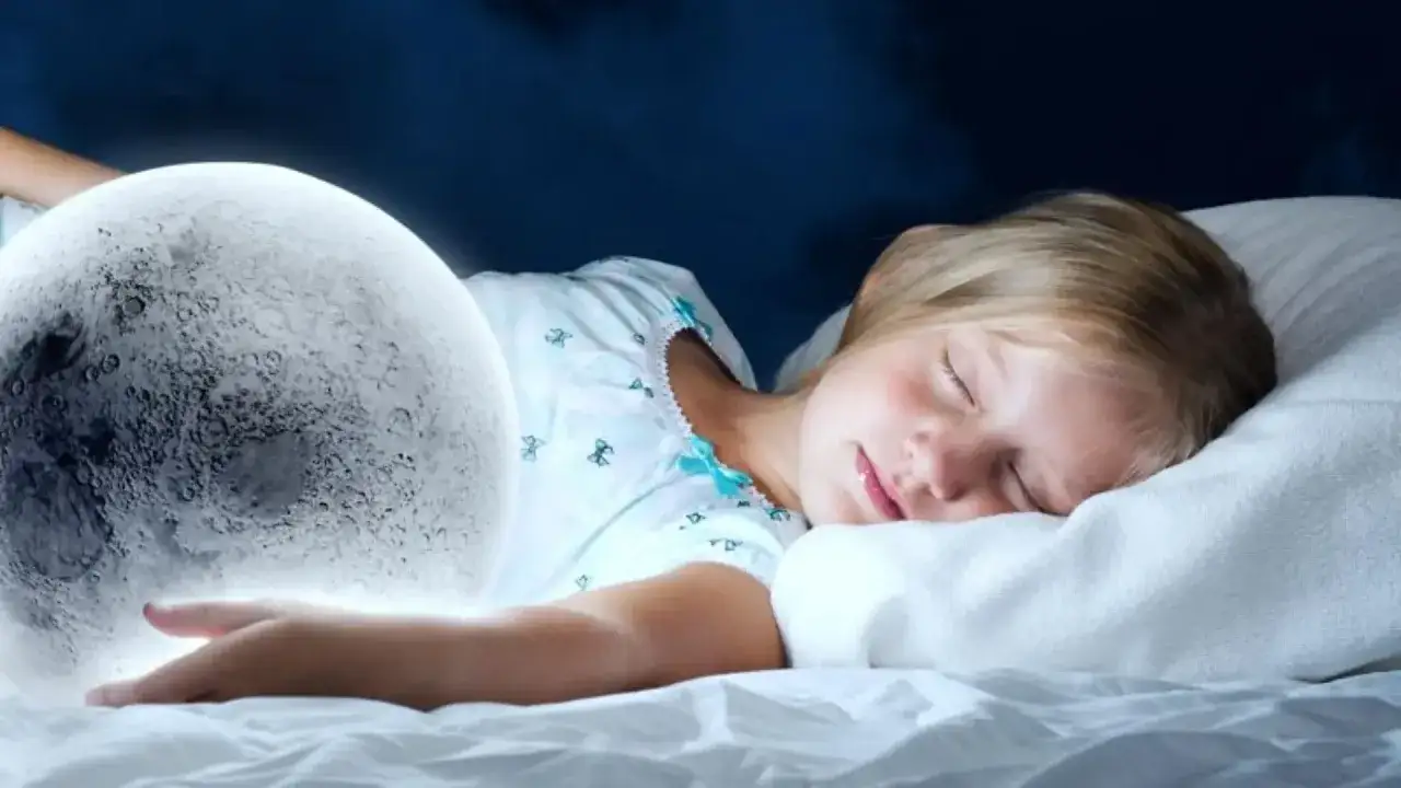 Ein 9-j&auml;hriges Kind hat Angst allein zu schlafen. Eine leuchtende Mondkugel liegt neben dem schlafenden Kind, das sich an sie kuschelt.