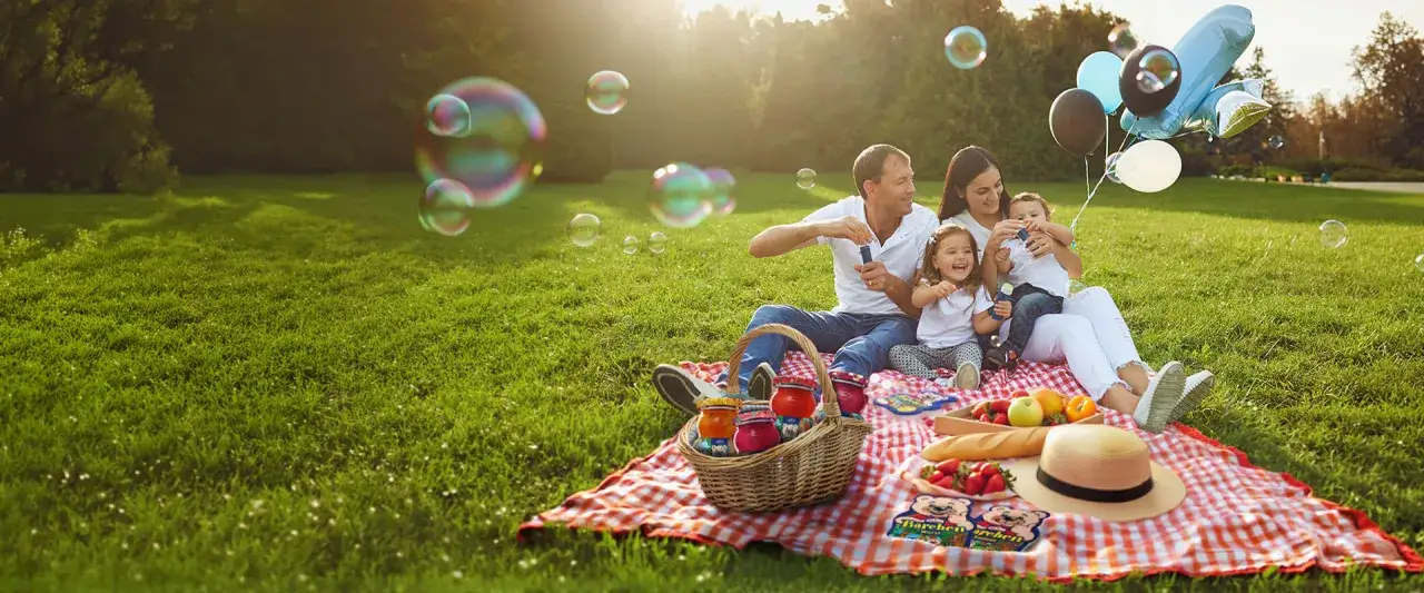 Familie feiert den Weltkindertag mit Seifenblasen und Ballons im Park.