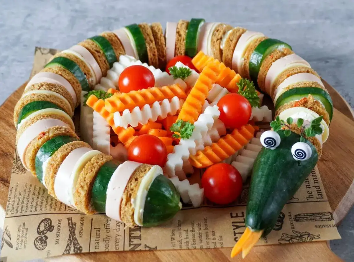 Kreative kita geburtstag ideen: ein lustiger Gurken-Wurm aus Brot, Wurst und Gemüse, der Kinder begeistert.