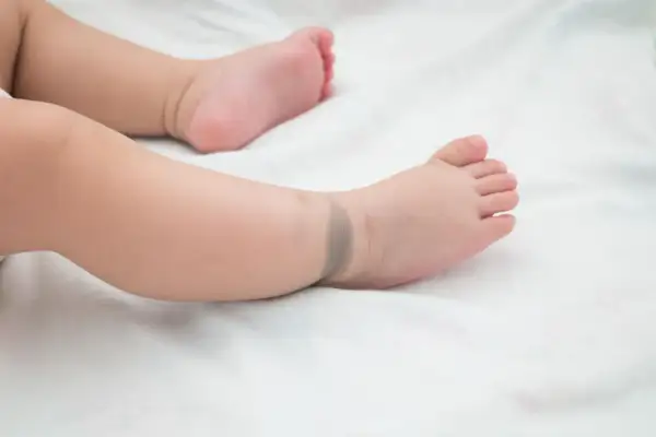 Ein Babyfuß mit einem bläulichen mongolenfleck am Knöchel.