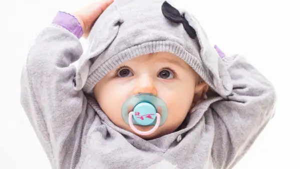 Baby mit Schnuller im süßen Elefanten-Hoodie. Bald ist er bereit zum schnuller auskochen.